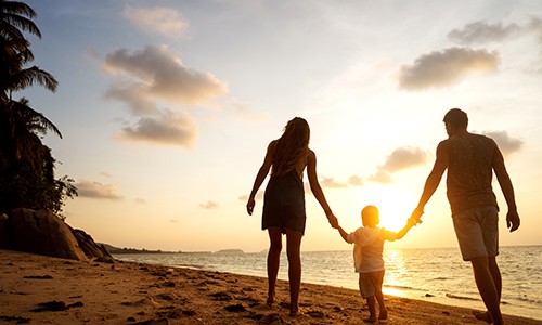 Family Walking On a Beach at Sunset